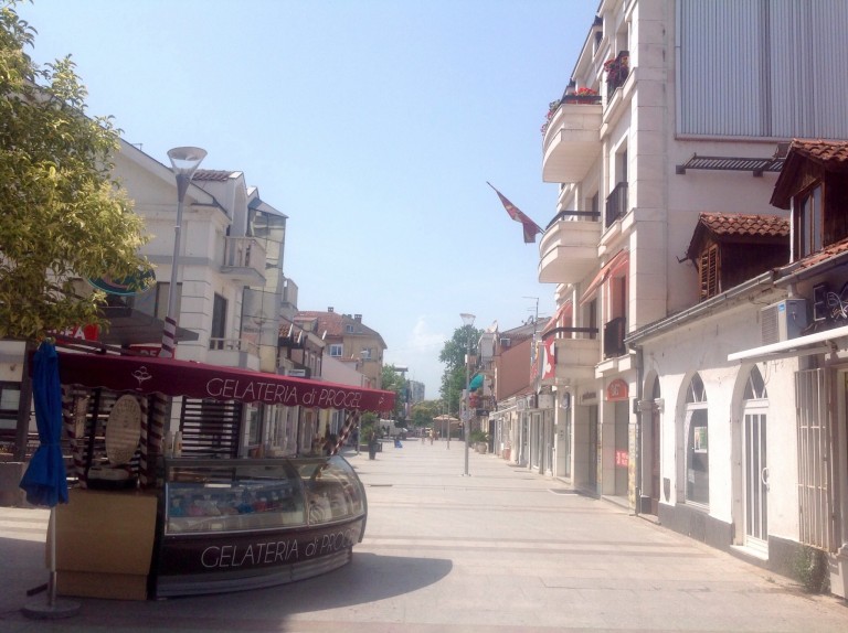 Vaaleita rakennuksia ja lähes tyhjä kävelykatu.