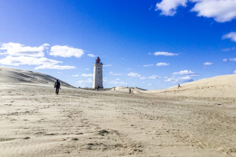 Hiekkadyyniä, kauempana näkyy majakka.