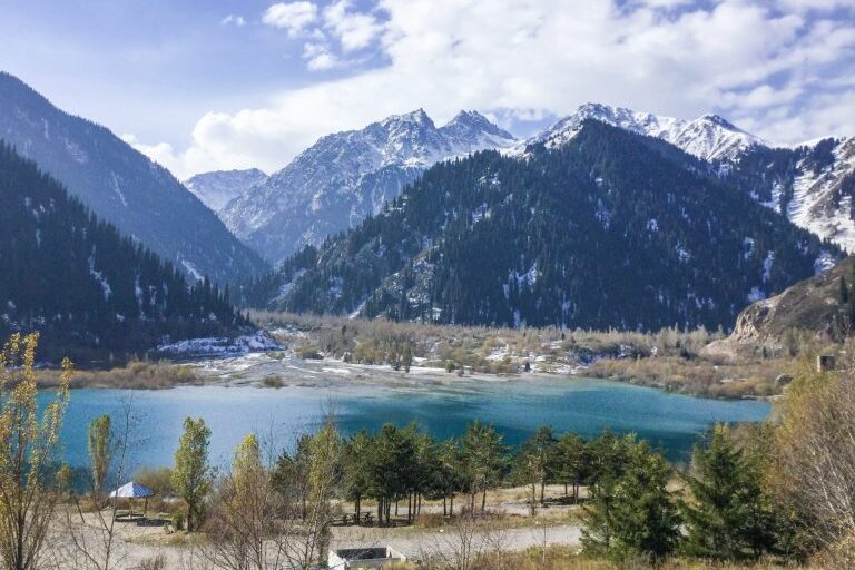 Pieni turkoosi Issyk-järvi, taustalla vuoret.