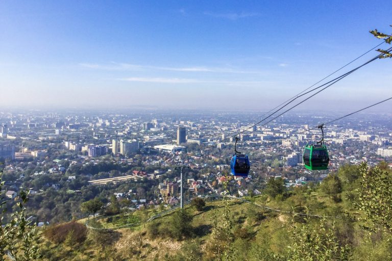 Kaksi köysiradan vaunua, taustalla näkyy Almatyn kaupunki.