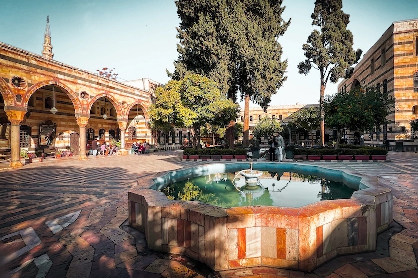 Palatsin sisäpiha, jossa pieni koristevesiallas ja puita.