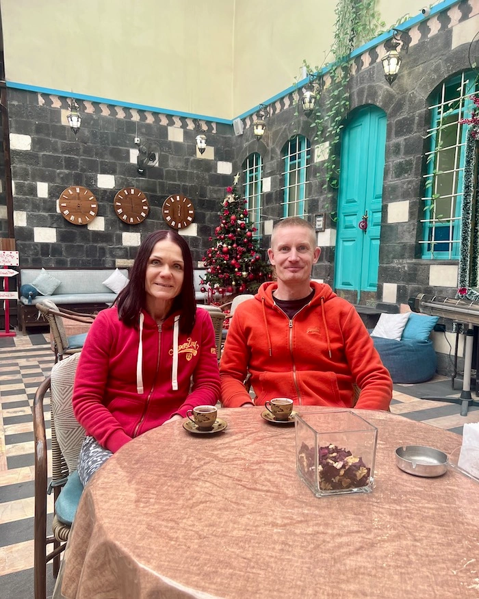 Turistipariskunta kahvilla pöydän ääressä Via Recta -hotellissa Damaskoksessa.