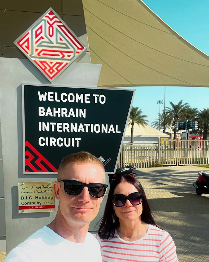Pariskunta Bahrainin formularadalla Welcome to Bahrain International Circuit -kyltin edessä.