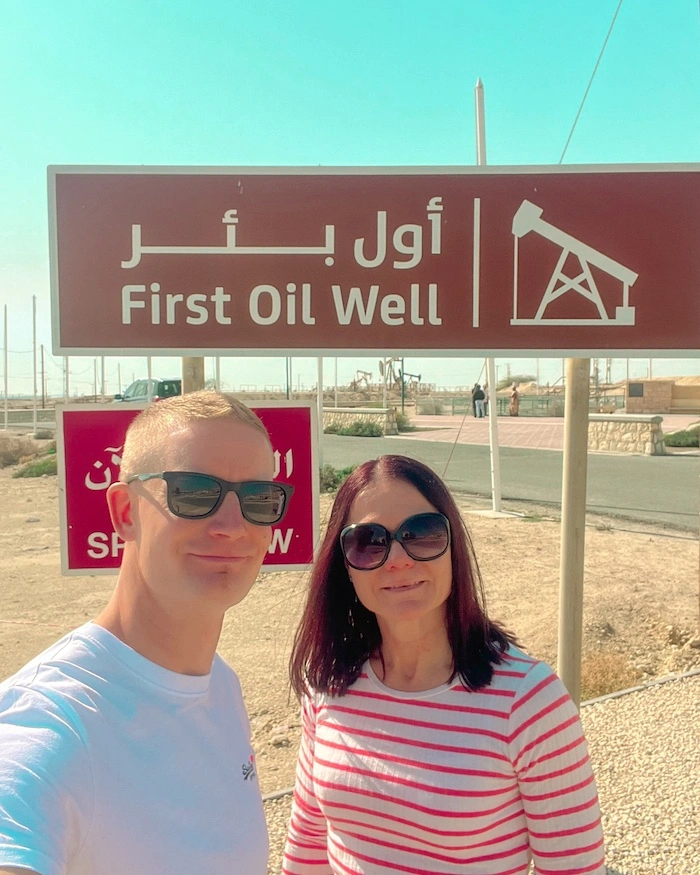 Pariskunta "First Oil Well" -kyltin edessä Bahrainissa.