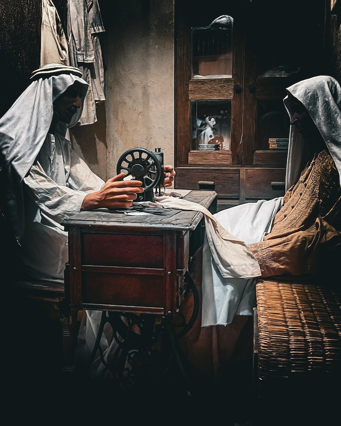 Bahrainin kansallimuseo diorama, jossa kaapuun pukeutuneita ihmisiä ompelijan luona.