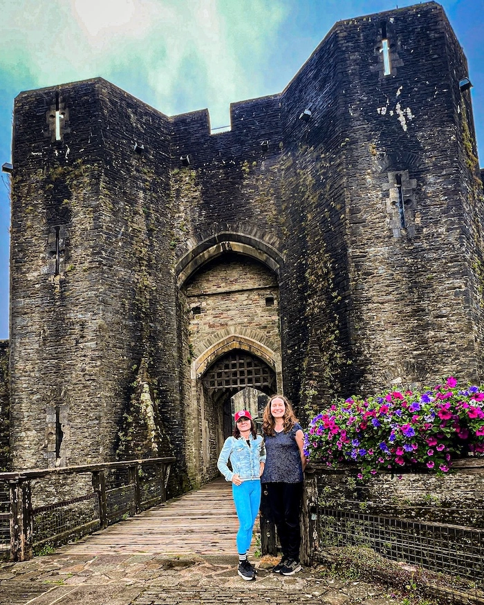 Kaksi naisturistia linnan pääsisäänkäynnin kohdalla Caerphillyssä, Walesissä