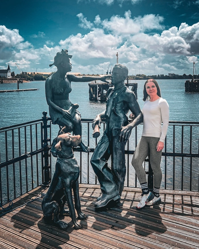 Turisti patsaiden vieressä Cardiff Bayssä