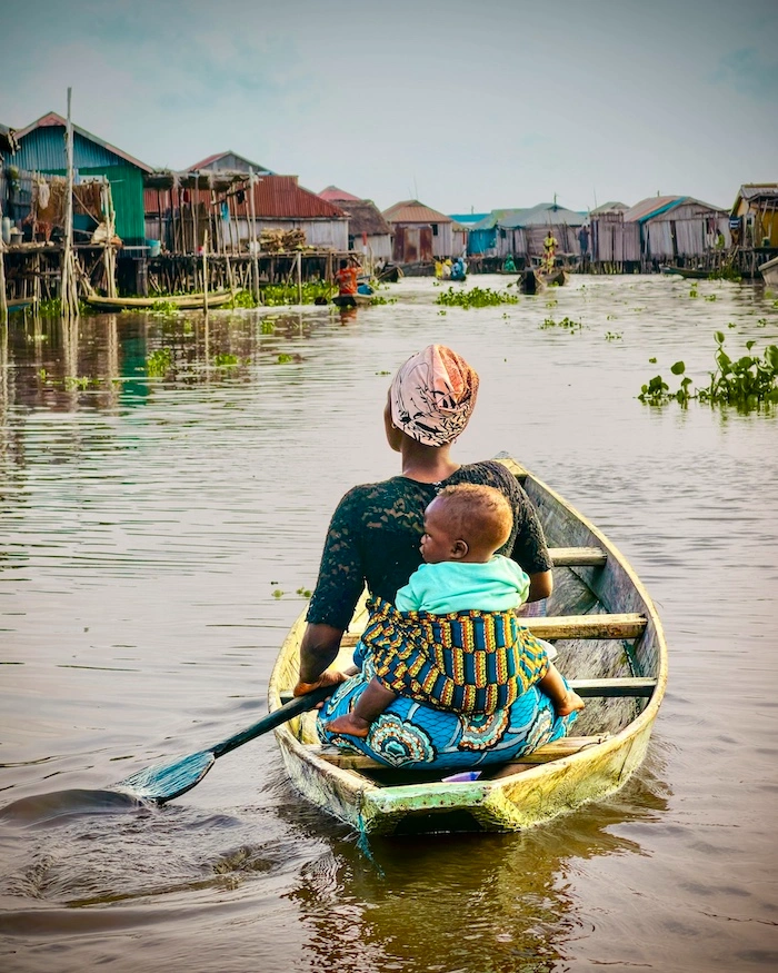 Nainen ja lapsi veneessä keskellä Makokon slummikylää Lagosissa, Nigeriassa.